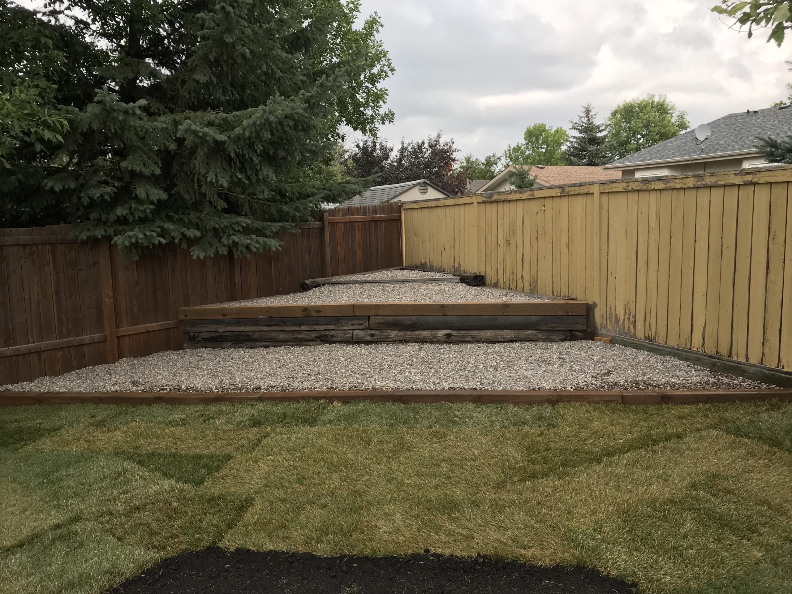 Tiered landscape beds filled with clean gravel rock for low-maintenance appearance