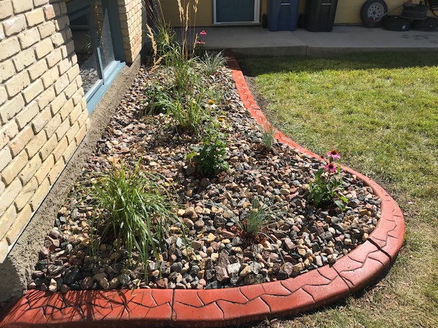 Mulch bed converted to river rock with perennials and decorative stone edging