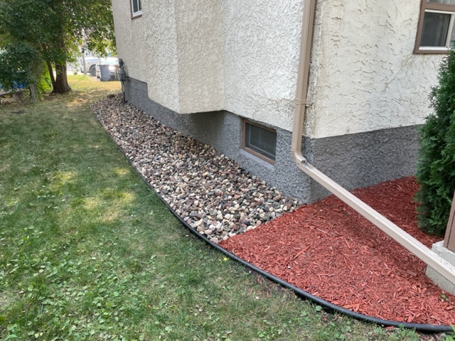 Rock bed refreshed with weed removal, new rock added, and edging repaired